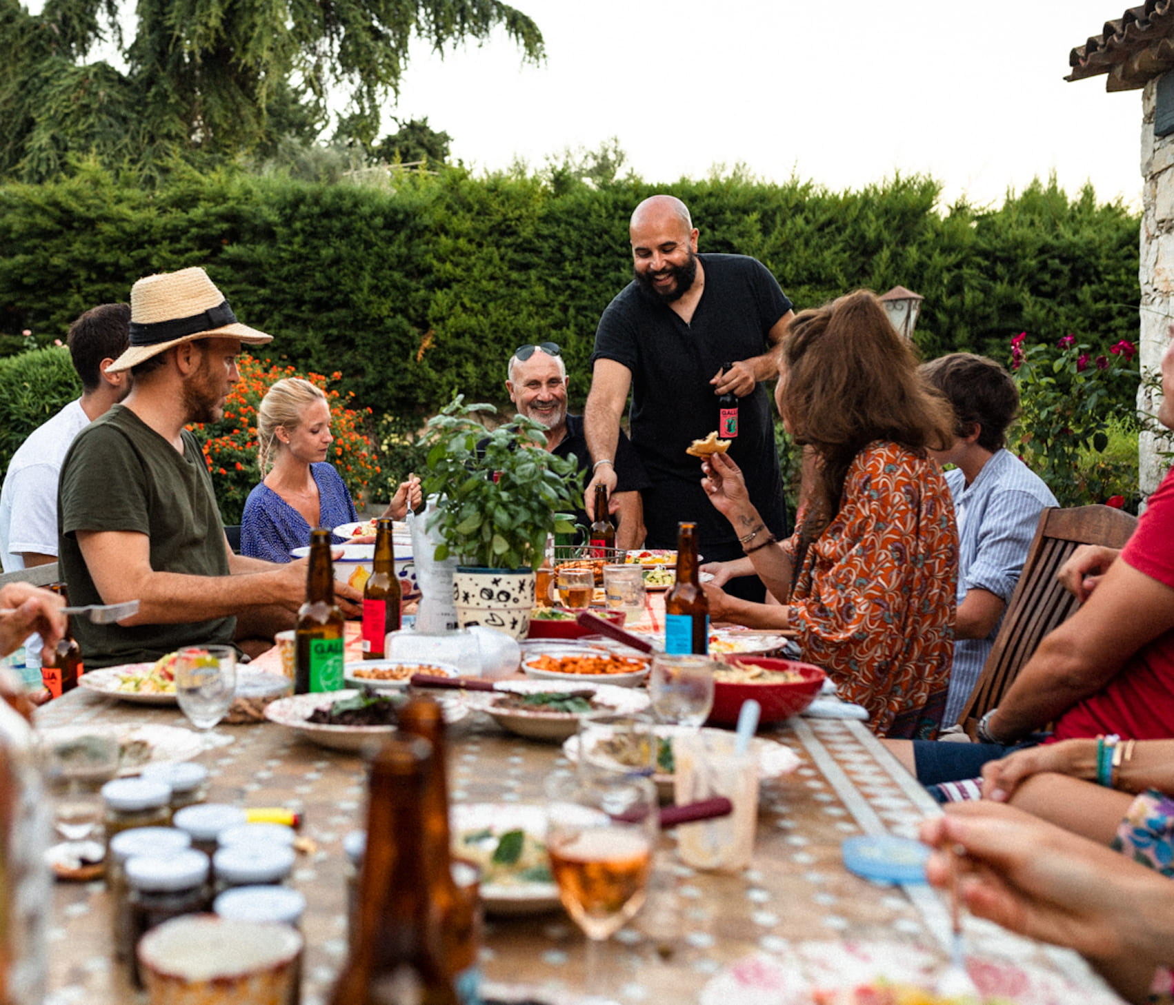 Image du fondateur Luc Sananes en train de présenter un repas préparer par Les Niçois sur une table extérieur, ambiance conviviale